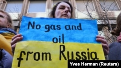 Плакат с надписью "Нет газу и нефти из России" на акции в поддержку Украины у посольства Германии в Бельгии. Брюссель, 11 марта 2022 года