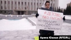 Участница пикета против возвращения мальчика, которого родители ставили коленями на гречку, в семью