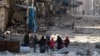 Syria -- Syrians walk over rubble of damaged buildings, while carrying their belongings, as they flee clashes between government forces and rebels in Tariq al-Bab and al-Sakhour neighborhoods of eastern Aleppo towards other rebel held besieged areas of Al